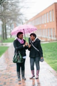 students sharing umbrella