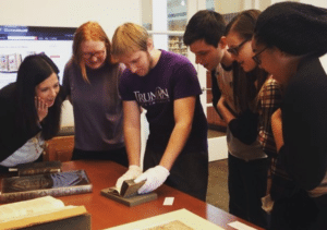 Students examining book in Special Collections