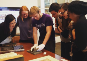 Students examining book in Special Collections