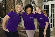 Three girls wearing purple T-shirts