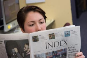 Student reading The Index newspaper