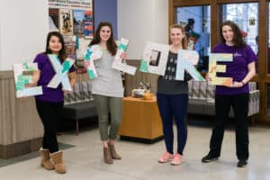 Students holding letters that spell the word explore