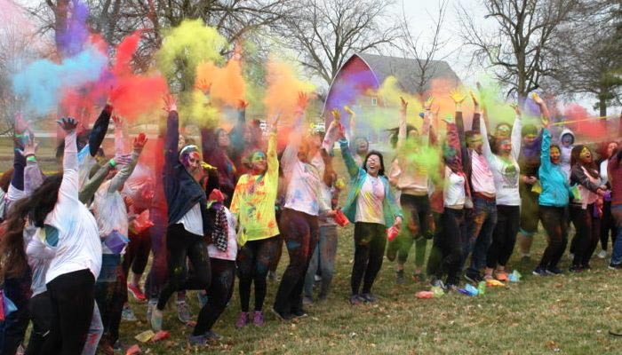 Students celebrating the Holi Festival with brightly colored powder