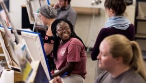 Student talking with professor in painting class
