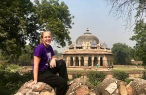 Girl sitting on a rock with a temple in background