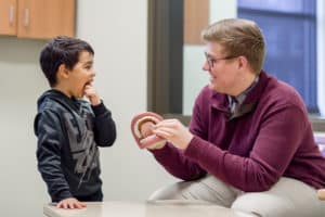 Student working with young child
