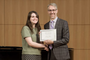 Professor presenting student with a scholarship award