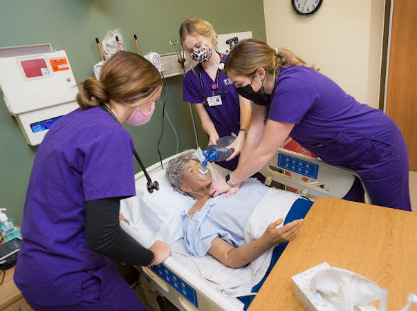 Three nursing students working on a patient